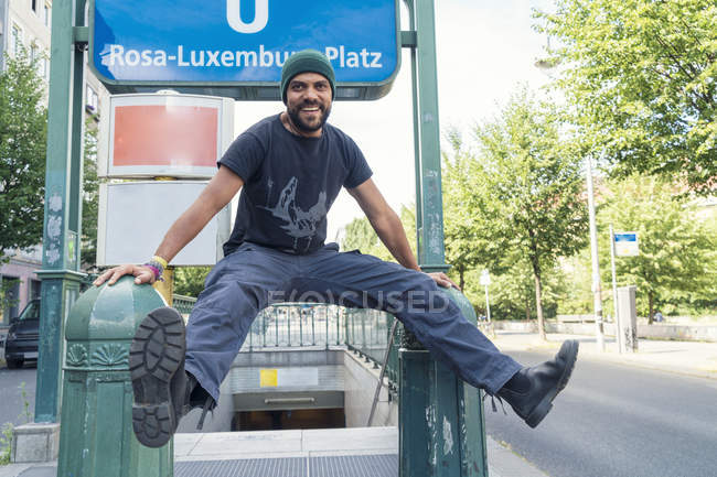 Young single in Berlin-Mitte, in front of underground sign Rosa-Luxemburg-Platz — Stock Photo