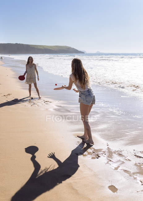 Две женщины играют на пляжных веслах на пляже — стоковое фото