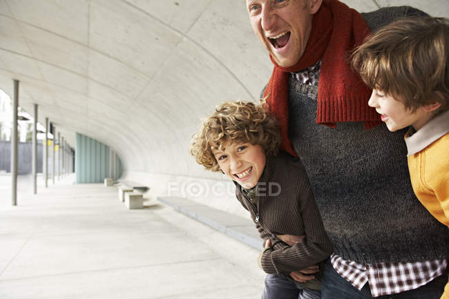 Stolzer lächelnder Vater, der Spaß mit Söhnen hat — Stockfoto