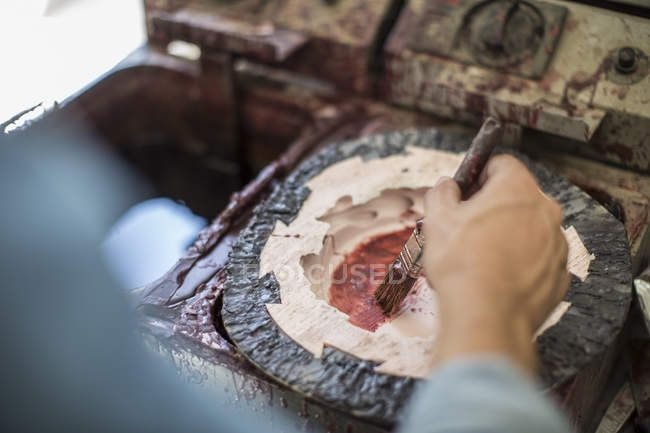 Cropped image of artist painting wax in mould — Stock Photo