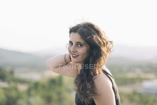 Retrato de mujer sonriente con la mano en el pelo - foto de stock
