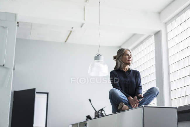 Seniorin sitzt im Kabinett — Stockfoto