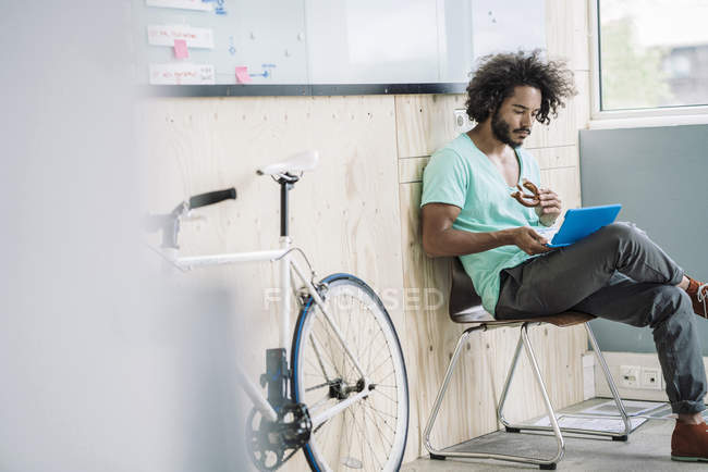 Designer sitzt auf Stuhl und benutzt Laptop — Stockfoto