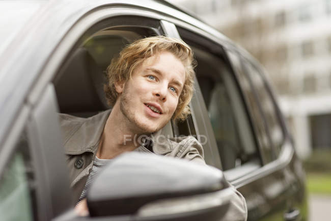 Человек, высунувшийся из окна машины — стоковое фото