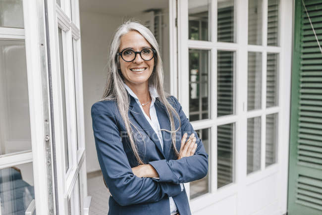 Businesswoman standing in front of house — Stock Photo