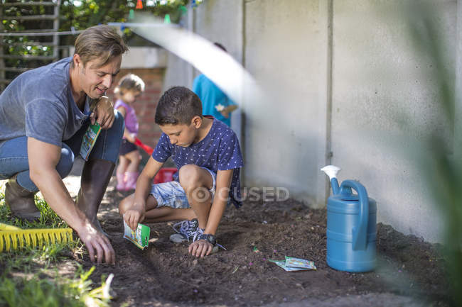 Father and son working together in garden — Stock Photo