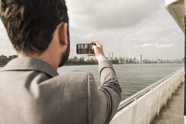 Uomo in traghetto sull'East River che scatta foto, New York, Stati Uniti — Foto stock