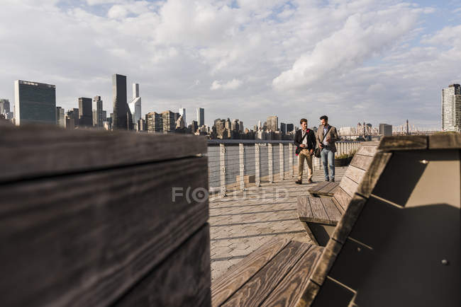 EUA, Nova York, dois homens de negócios caminhando ao longo de East River — Fotografia de Stock
