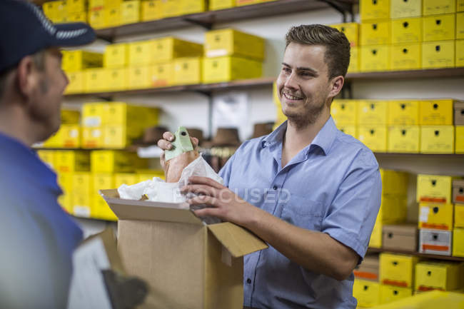 Homme en entrepôt contrôle livré boîte en carton — Photo de stock