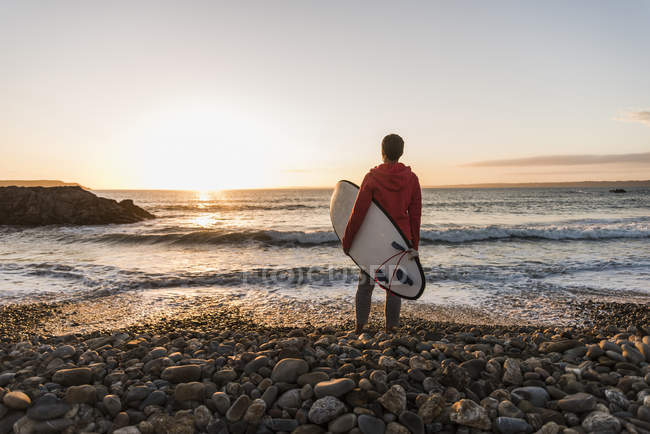 Mujer con tabla de surf en Finistere of Brittany, Península de Crozon, Francia - foto de stock