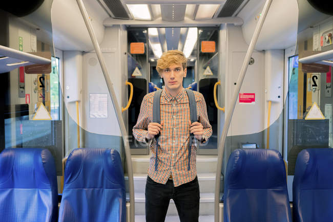 Junger Mann mit Rucksack steht im Zug — Stockfoto