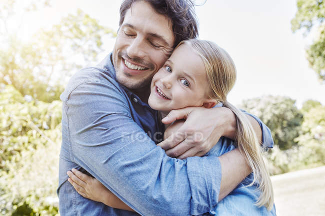 Padre e figlia sorridenti che si abbracciano all'aperto — Foto stock