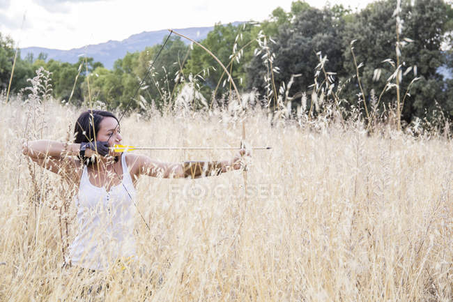 Giovane arciera sportiva mira con il suo arco — Foto stock