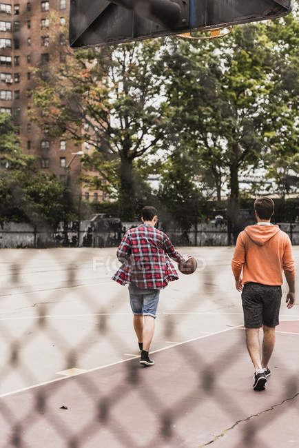 Due giovani con pallacanestro passeggiando all'aperto — Foto stock