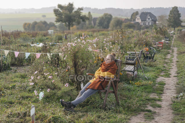 Jovem relaxante no jardim da casa de campo — Fotografia de Stock