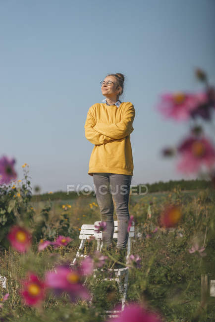 Souriant jeune femme dans le jardin cottage — Photo de stock