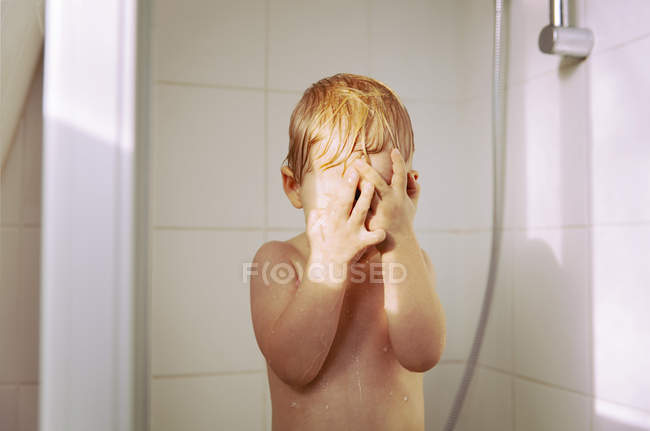 Ragazzino che fa la doccia e copre gli occhi con le mani — Foto stock