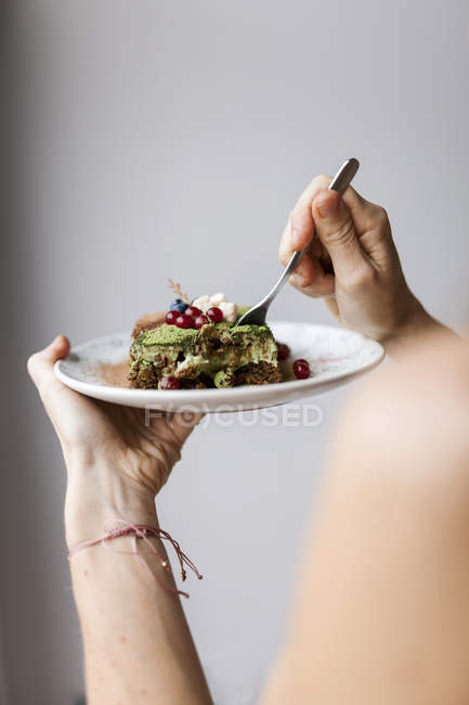 Woman eating vegan matcha cake — Stock Photo