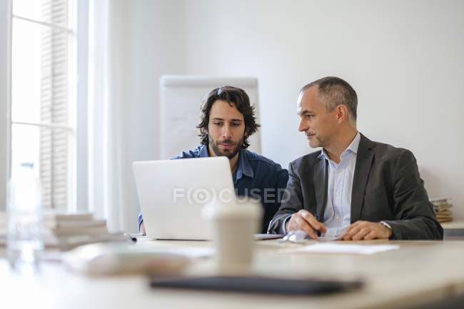 Dos hombres de negocios trabajando juntos en el cargo - foto de stock