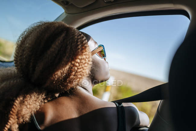 Jovem mulher olhando pela janela do carro — Fotografia de Stock