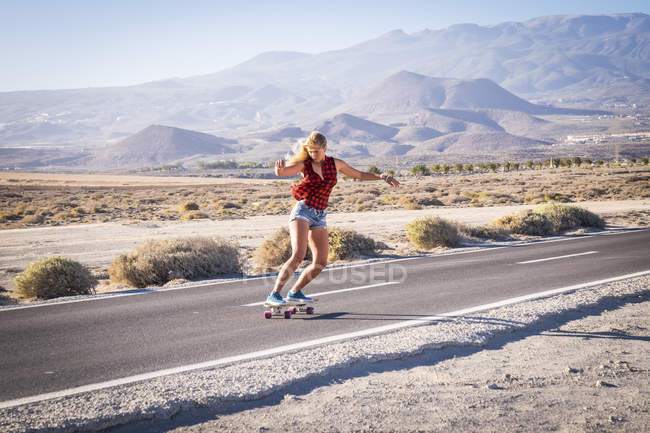 Spanien, Teneriffa, blonde junge Skater Skateboarding auf leerer Straße — Stockfoto