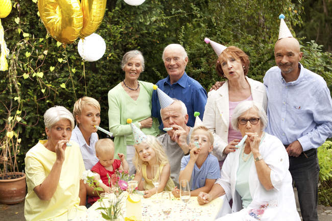 Extended family and friends having birthday party in garden — Stock Photo
