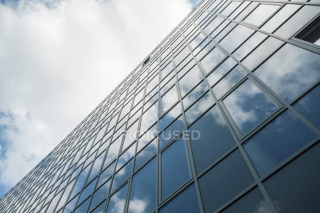 Modern glass facade reflecting clouds — Stock Photo