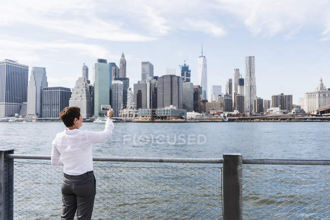 Femme d'affaires prenant une photo de Manhattan skyline, USA, New York — Photo de stock