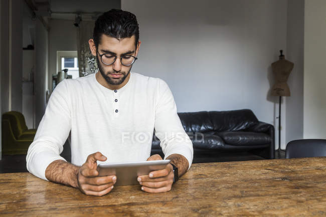 Jeune homme utilisant une tablette numérique dans un bureau moderne — Photo de stock