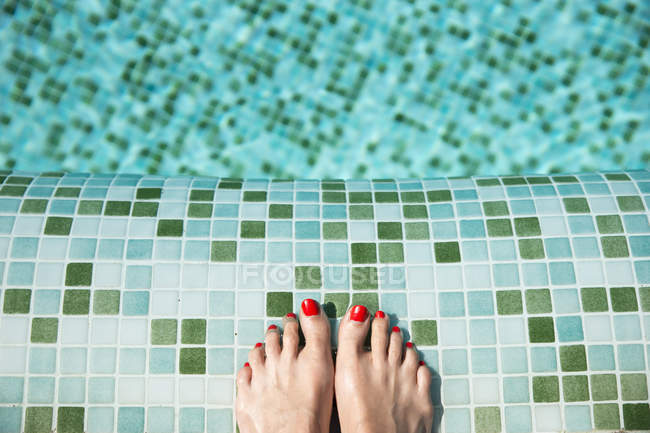 Woman's feet at poolside — Stock Photo