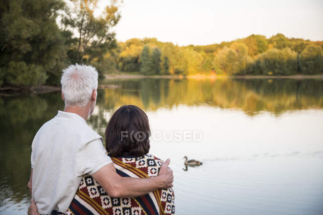 Seniorenpaar schaut Ente am See an — Stockfoto