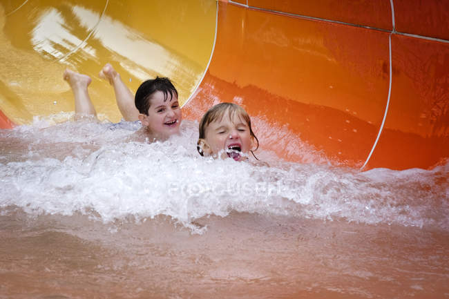 Two boys having fun on water slide — Stock Photo