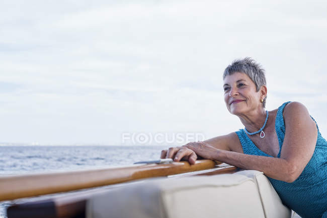 Усміхнена жінка під час подорожі на човні дивиться на — стокове фото