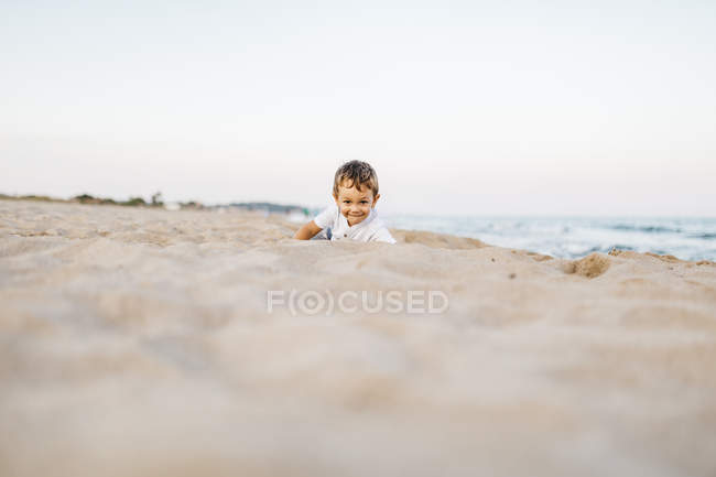 Cute caucasian little boy having fun on sandy beach — Stock Photo