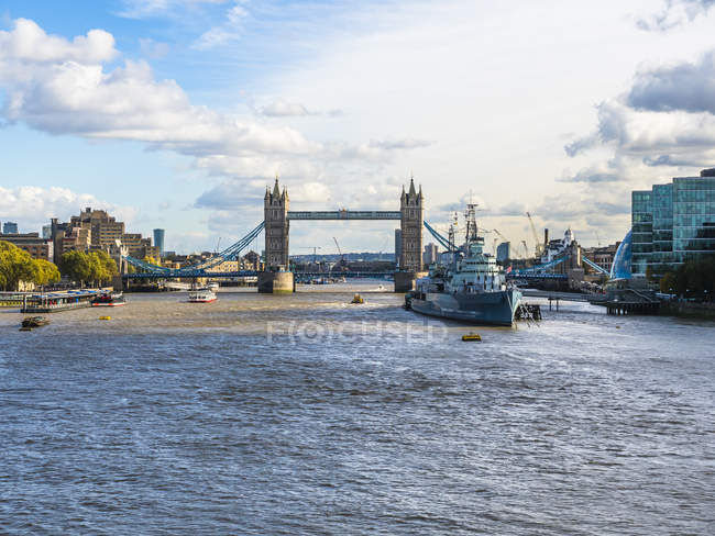 Reino Unido, Londres, vista al barco museo HMS Belfast en el río Támesis con Tower Bridge en el fondo - foto de stock