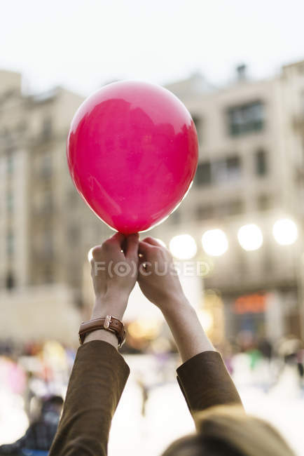Female hands holding pink balloon — Stock Photo