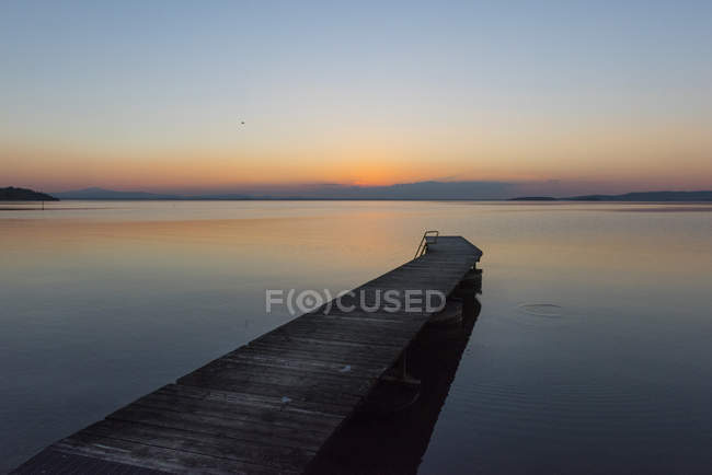 Italie, Ombrie, Coucher de soleil sur le lac Trasimène sur l'eau — Photo de stock