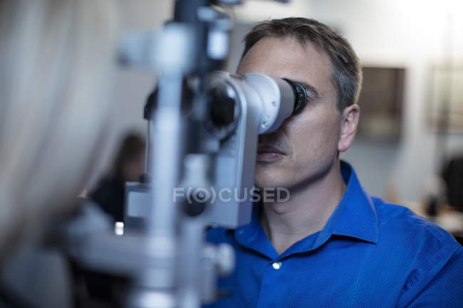 Optometrist doing eye test with patient in medical clinic — Stock Photo