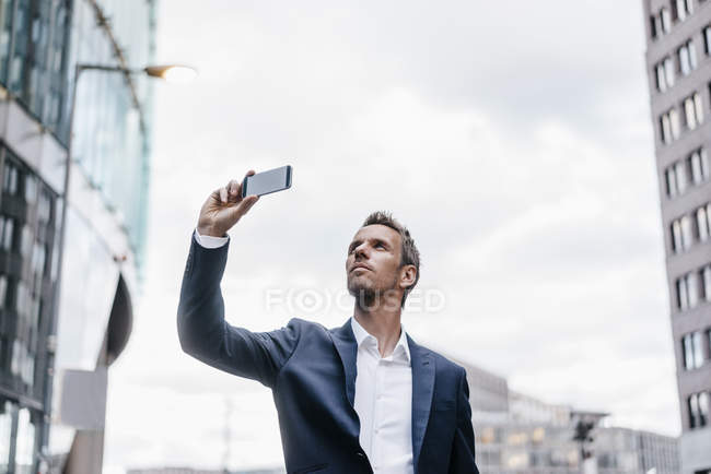 Uomo d'affari che scatta foto con il cellulare — Foto stock