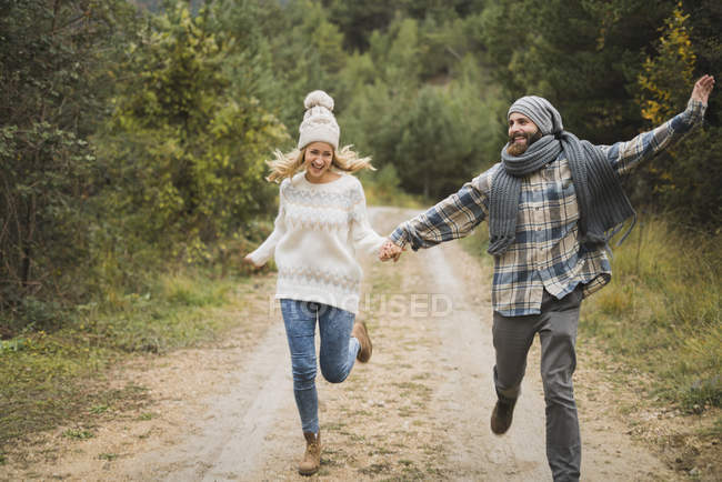 Glückliches junges Paar läuft im Herbst auf Wanderschaft — Stockfoto