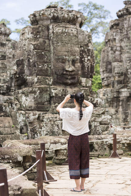 Cambogia, Siem Reap, Angkor Thom, vista posteriore del turista che fotografa il tempio di Bayon — Foto stock