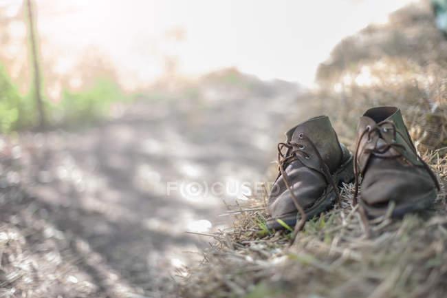 Coppia di stivali vecchi in una fattoria su sfondo azzurro — Foto stock