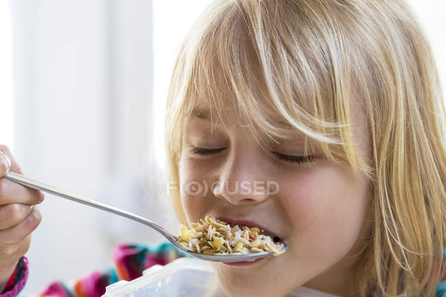 Маленькая девочка ест мюсли — стоковое фото