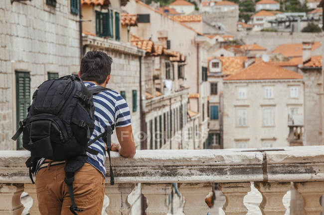 Rückansicht des Touristen mit Rucksack mit Blick auf die Stadt — Stockfoto