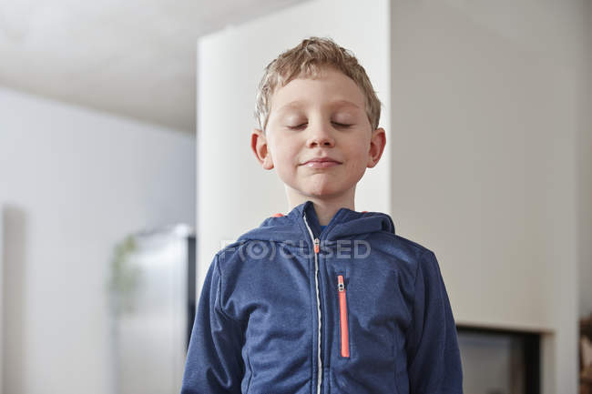 Boy closing eyes and standing at home — Stock Photo