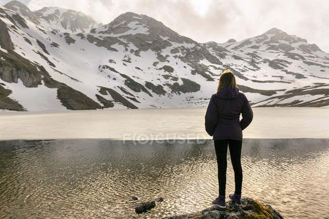 Mulher de pé no lago de montanha, Espanha, Astúrias, Somiedo — Fotografia de Stock