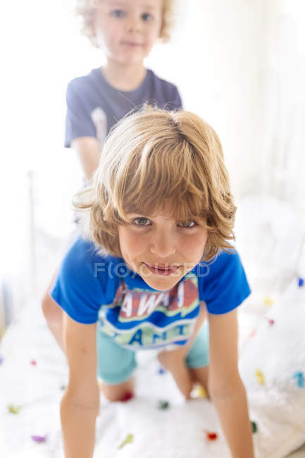 Ritratto di ragazzo sorridente che gioca con il suo fratellino a casa — Foto stock