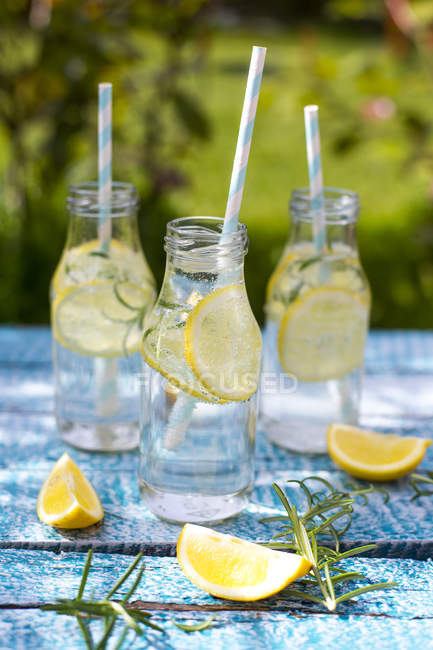 Fette Di Limone E Rosmarino E Bottiglie Di Limonata Fatta In Casa Sul Tavolo Da Giardino Mangiare Sano Primo Piano Stock Photo 176831072