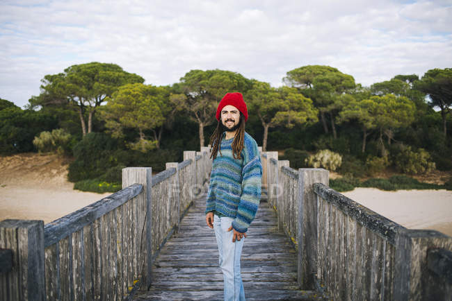 Молода людина з дреди і вовняні шапки на дерев'яний міст — стокове фото