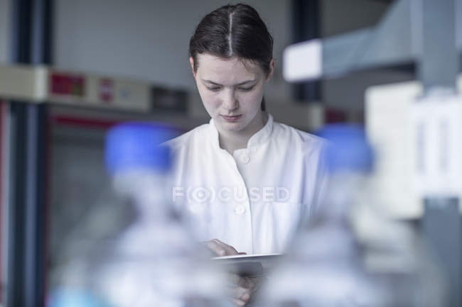 Technicien de laboratoire utilisant une tablette numérique en laboratoire — Photo de stock
